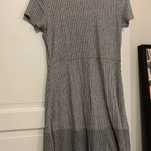 Grå ribbad klänning från GAP - Säljer en snygg grå ribbad klänning från GAP i storlek M. Klänningen har korta ärmar och en bekväm passform. Den är i mycket bra skick och redo för en ny ägare. 