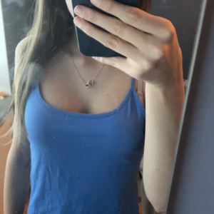 Blå linnetopp från KappAhl - Säljer en snygg blå linnetopp från KappAhl, perfekt för sommardagar. Toppen är ärmlös med smala axelband och har en enkel och stilren design. Materialet känns mjukt och bekvämt mot huden. Passar både till vardags och festliga tillfällen. 