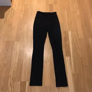 Säljer ett par svarta leggings i mycket bra skick. De är högmidjade och har en tight passform, perfekta för både vardag och träning. Materialet är mjukt och stretchigt, superbekväma att ha på sig. De har en slits längst ner vid benet.