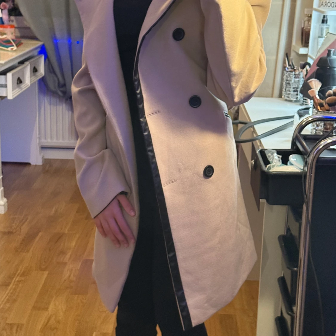 Beige kappa med svarta knappar