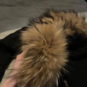 Svart vinterjacka med päls från Hollies - Säljer en svart vinterjacka från Hollies i storlek 34 . Jackan har en mysig pälsdetalj på huvan och är perfekt för kalla dagar. Den har dragkedja och knappar framtill för extra skydd mot kyla. Pris går att diskutera 