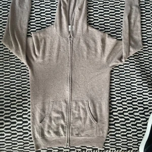 Beige cashmere hoodie från John Henric - Säljer en supermjuk och stilren beige hoodie i kashmir från John Henric. Perfekt för kyliga dagar med sin dragkedja och praktiska fickor. Den är i mycket bra skick och passar både till vardags och lite finare tillfällen. Bra cond men har ett litet hål som ni ser på bilden, bara komma dm vid frågor. Nypris 2400