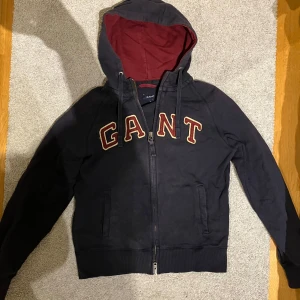 Svart hoodie från GANT - Säljer en snygg svart hoodie från GANT i storlek M. Två dragtjedjor och den är i hyfsat bra skick 