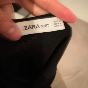 Halterneck bodysuit från Zara - Säljer en stilren svart halterneck bodysuit från Zara. Den är ärmlös med en backless-design som ger en modern look. Perfekt för både vardag och fest! Materialet är mjukt och stretchigt för en bekväm passform. Köp den nu och uppgradera din garderob! 🖤