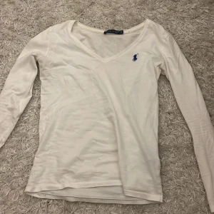 Vit långärmad tröja från Ralph Lauren - Säljer en vit långärmad tröja från Ralph Lauren i storlek XS. Den är i bra skick men har lite märke på användning. ( små hål vid magen! ) Originalpris: 2200