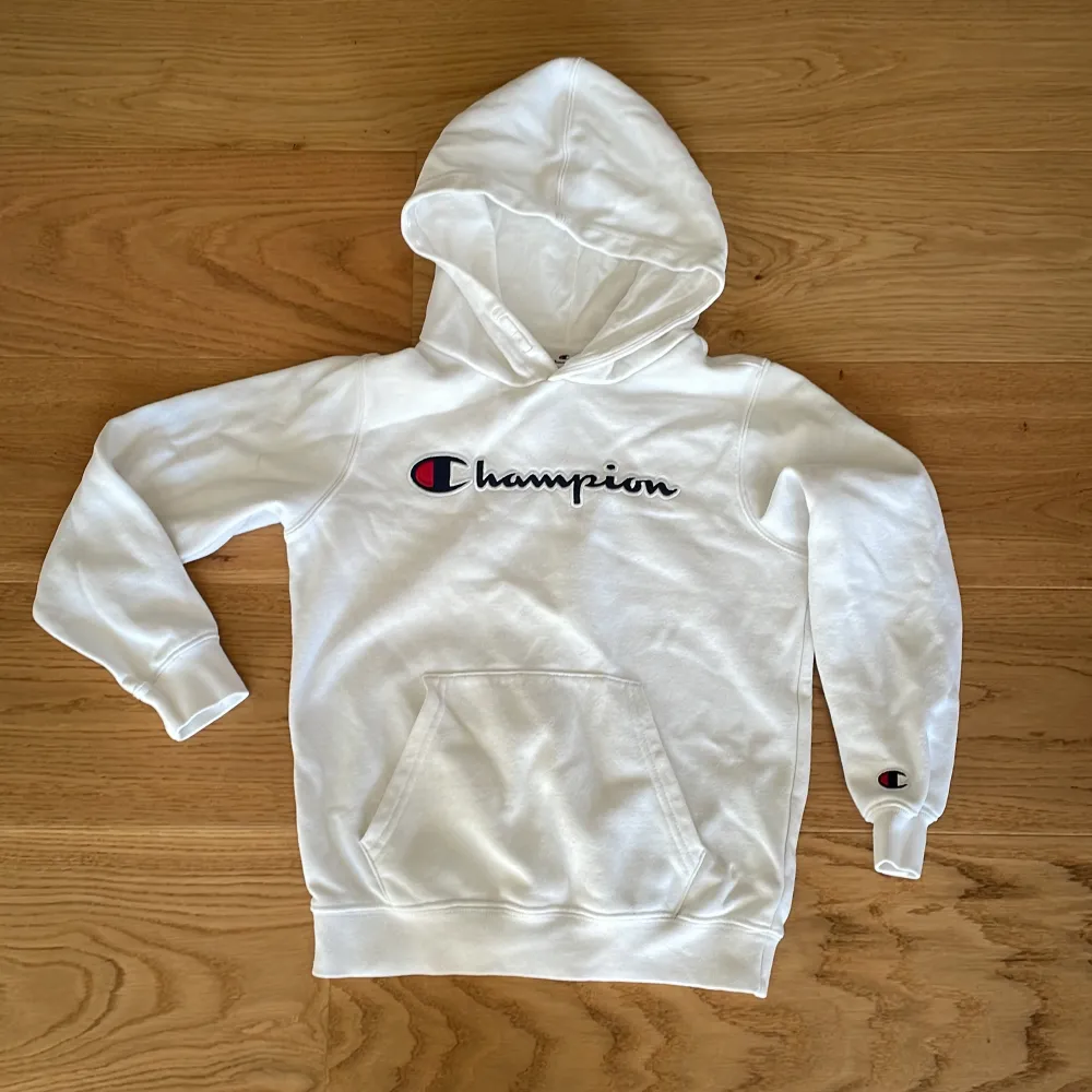 Vit lite tunnare hoodie från Champion i storlek M för barn 9-10 år. Bra luva och stor ficka framtill. Djur- och rökfritt hem. . Hoodies.