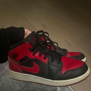 Air Jordan 1 mid - Röda air jordans mid 1 i storlek 39, normal i strlk. Väldigt fint skick! Inga defekter, inga hål osv. Nypris 2299kr säljer för 799kr. Man får med skollådan som dom kom i.