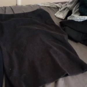 Svart kjol - Säljer en stilren svart kjol i normal passform. Perfekt för både vardag och festliga tillfällen. Kjolen är i ett mjukt material som känns bekvämt mot huden. Ett måste i garderoben för alla säsonger!