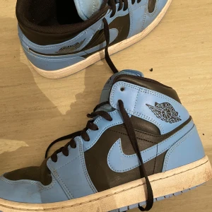 Air Jordan 1 Mid 'University Blue Black' - använder inte längre, och kan användas av både manligt och kvinnligt.