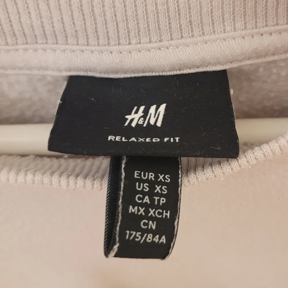 Säljer en stilren beige sweatshirt från H&M i storlek XS. Den har en relaxed fit och är perfekt för både vardag och mysiga hemmakvällar. Tröjan är långärmad och gjord i ett mjukt material som känns skönt mot huden. Passar perfekt till höst och vår!. Tröjor & Koftor.