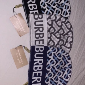 Mönstrade mössor från Burberry - Säljer tre snygga mössor från Burberry med deras ikoniska logga. Ena mössan är i grått och den andra i blått, och den sista svart, tre mössor med ett coolt mönster i ljusblått, vitt och svart. Perfekta för att hålla stilen i vinterkylan! 🧢✨ Priset kan diskuteras vid en snabb affär. Obs! Priset är för styck.