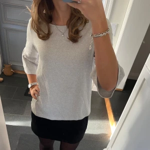 Grå stickad tröja  - Grå trekvartsärmad tröja med volanger från Street One i storlek 38. Fint skick. Använd gärna köp nu!