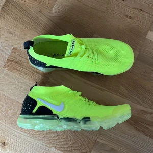 Nike Vapormax Flyknit 2.0 Volt - Säljer ett par Vapormax Volt, då de aldrig kommer till användning. Endast använda en löptur. De är inte original! Finns en liten fläck långt upp på hälen. (Kolla sista bilden) Storlek 43. Skick 9/10.