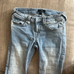 Ljusblå jeans från True Religion - Säljer ett par snygga ljusblå jeans från True Religion i modellen Joey. Säljs då de aldrig kommer till användning. Har klippt dom längst ner men det har inte påverkat modellen på byxorna. Fortfarande lite långa i benen på mig som är 155. Innerbenslängden är 71cm!