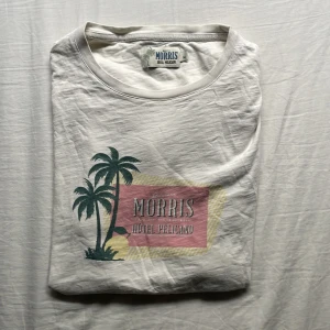 MORRIS T SHIRT - Tjena, säljer en vit Morris t shirt från deras hotell pelicano kollektion. Den är i riktigt bra skick och riktigt fet. Tröjan är storlek M men är lite mindre k storleken. Hör av dig vid frågor, priset är inte hugget i sten!