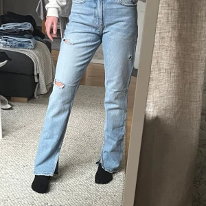 Jeans med slits - Säljer ett par ljusa jeans i mycket bra skick. De har medelhög midjade och har en straight passform. Jeansen har coola slitningar på knäna och är perfekta för en avslappnad stil. Passar bra till både vardag och fest!