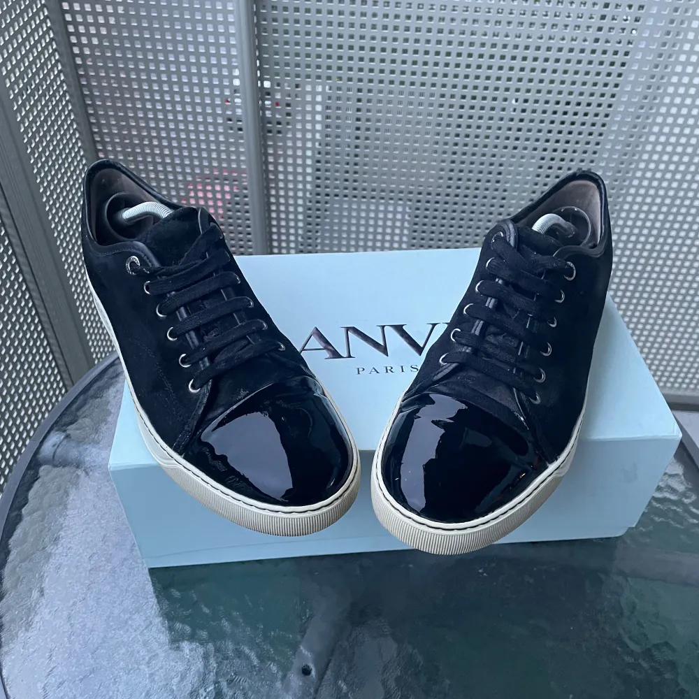 Säljer ett par snygga svarta sneakers från Lanvin i mycket bra skick. Skorna har en glansig finish på tån och snörning framtill. Använda fåtal gånger. De kommer med originalkartong, kvitto och extra snören🧾👞. Storleken uk 9 som motsvarar storlek 43/44 passar även dig med 42 om man lägger ner sula. Perfekta för både vardag och speciella tillfällen. (Lite blöta pågrund av rengöring) frågor eller annat skriv i dm. . Skor.