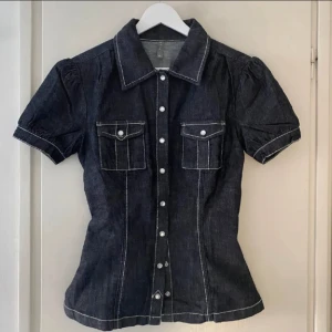 Figursydd jeansskjorta  - Figursydd jeansskjorta, så coolt och unikt plagg. Snygg passform, bra skick!! Köpt vintage 