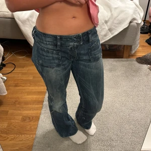 Blå jeans från Diesel - Säljer ett par snygga blå jeans från Diesel i bra skick. De har en cool detalj med nitar på bakfickan. Jeansen har en straight passform och sitter så snyggt. De är lågmidjade. Jag brukar ha storlek 80 i midjan och de passar perfekt. Är 160cm lång som referens ❣️