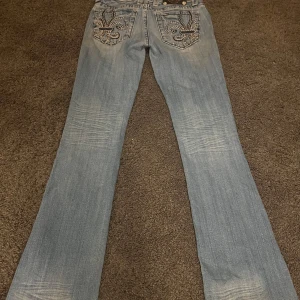 Ljusblå bootcut miss me jeans - Säljer ett par snygga blå bootcut jeans från Miss Me i storlek 26. De har ett coolt broderi på bakfickorna och är i bra skick. Pris kan diskuteras🔥.                             Midja rakt över: ca 36cm❤️Innerbenslängd: ca 82cm