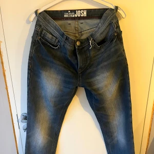 Blå jeans från Tom Tailor - Säljer ett par snygga blå jeans från Tom Tailor, modell Josh. De har en regular slim passform och är i bra skick. Perfekta för både vardag och fest! De är tillverkade i slitstarkt denim och har en snygg tvättad look. Storlek 30/34
