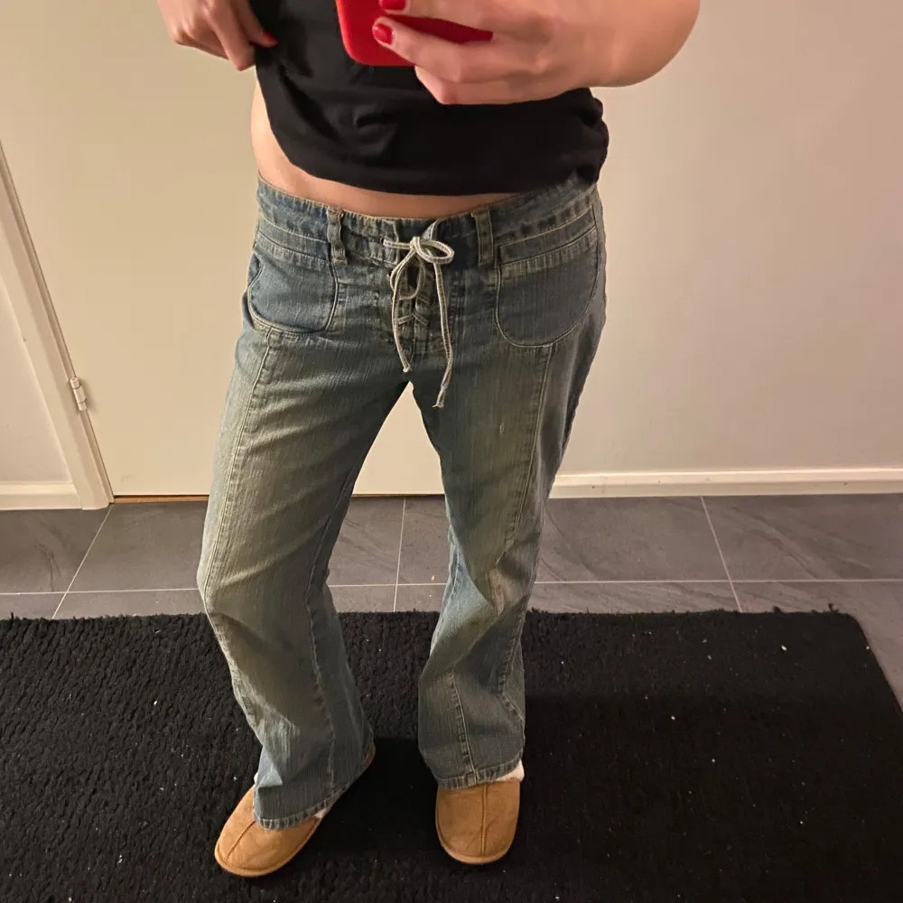 Säljer ett par snygga blå jeans med snörning framtill. De har en avslappnad passform och bootcut. Jeansen har fickor både fram och bak. 💓 midjemått 39-40cm. Jeans & Byxor.