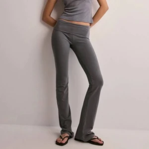 Yoga pants - Snygga grå bootcut byxor i stretchigt material. Perfekta för en avslappnad stil eller en dag på stan. De har en tight passform upptill och blir vidare nedtill, vilket ger en skön och trendig look. Passar bra till både sneakers och sandaler. Köpta från nelly!