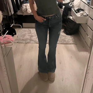 Blå bootcut jeans - Säljer ett par snygga blå bootcut jeans i bra skick. De är lågmidjade och har en klassisk femficksdesign. Perfekta för både vardag och fest! Passar till allt från sneakers till klackar.