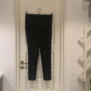 Svarta skinnbyxor med krokodilmönster - Säljer ett par svarta skinnbyxor med coolt krokodilmönster. De är tighta och perfekta för en utekväll eller fest. Byxorna har en hög midja och är i mycket bra skick. Passar perfekt till en snygg topp och klackar!