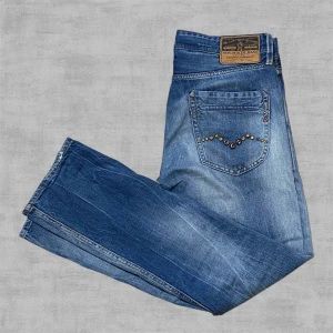 Reglay Jeans med nitar | Straight Leg | W31 L32 - Unika Replay Jeans med snygg tvätt i en rak och avslappnad passform. Stål nitar på bakfickorna.  Super bra skick, helt fria från skador och slitage.   OBS! SMUTSIG SPEGEL, BYXORNA ÄR FLÄCKFRIA