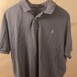 Blå Ralph Lauren Pikétröja  - Blå Ralph Lauren Piké i storleken XL. Tröjan är i mycket bra skick! Nypris 1195kr!  Tröjan kommer från ett rökfritt hem. Kan skickas med postpaket mot förskottsbetalning om så önskas eller blocketpaket. Köparen betalar frakten. Tar Swish. Fler bilder kan skickas. Finns annonsen kvar finns tröjan kvar! Klicka på min profil nederst i annonsen så ser du alla mina annonser. Kan skicka paket med flera annonser.