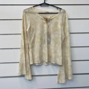 Bohemian Blus - En super snygg blus med utsvängda ärmar. Den är i krämig och vit färg och passar super bra in i boho chic stilen! Storlek M!