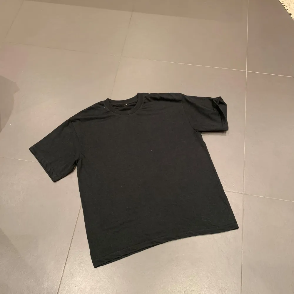 Säljer en svart t-shirt med texten 'Need Money for Porsche' i vit på baksidan. Den har en normal passform och är kortärmad, perfekt för en avslappnad stil. T-shirten är i bra skick och gjord av bomull, vilket gör den bekväm att bära.. T-shirts.