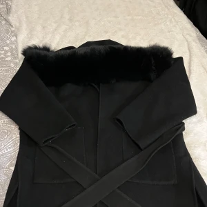 Kapa med svart päls - En svart kappa med svart äkta päls kragge. Köpt förra året använd bara några gånger. Köpt för 3000kr.