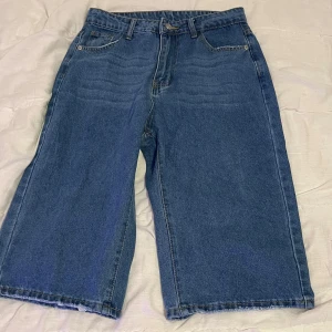 Blå jeansshorts från Shein - Säljer ett par blå jeansshorts från Shein i storlek 30. De har en klassisk femficksdesign och är tillverkade i bomullsmaterial för en bekväm känsla. Perfekta för en avslappnad look den är knä längd säljs för 50