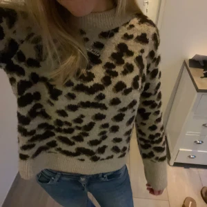 Leopardmönstrad tröja - Säljer en supercool leopardmönstrad tröja. Den är i beige och svart med en skön, stickad känsla. Perfekt för höst och vinter med sina långa ärmar och ribbade kanter. Passar perfekt till jeans för en avslappnad men stilren look. 🐆✨