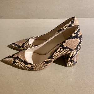 Ormmönstrade pumps från Zara - Snygga ormmönstrade pumps från Zara i storlek 39 och klacken är 8 cm bak. De har en spetsig tå och en stabil klack som ger en elegant look. Perfekta för en utekväll eller fest! Skorna är i mycket bra skick och har bara provats en gång inomhus!  