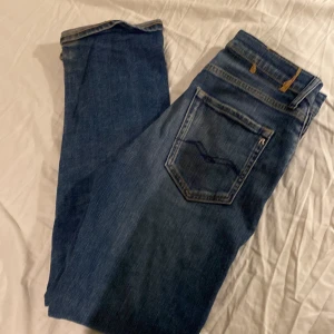 Blå jeans från Replay - Säljer ett par snygga blå jeans från Replay. De har en klassisk femficksdesign och är i mycket bra skick. Perfekta för både vardag och fest! Passar bra till en casual look eller med en snygg skjorta för en mer uppklädd stil.
