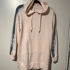 Ljusrosa klänning Calvin Klein - Skön hoodieklänning från Calvin Klein.