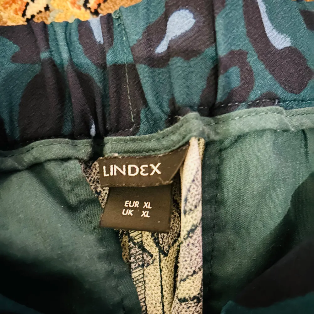 Säljer ett par coola byxor från Lindex i storlek XL. De har ett leopardmönster i svart och grönt, perfekt för att sticka ut lite extra. Byxorna har en loose passform och är superbekväma. Perfekta för både vardag och fest!. Jeans & Byxor.