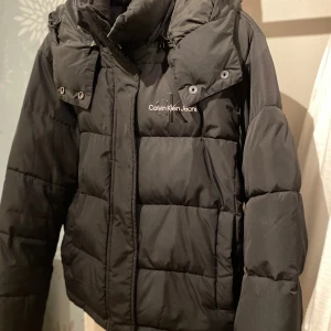 Calvin Klein jacka  - Säljer min svarta Calvin Klein vinterjacka som är i gott skick, men använd. Den är i storlek M och har fickor på framsidan som stängs med en knapp. Öppen för prisförslag. Skriv vid intresse, frågor osv🩷nypris ca 1900