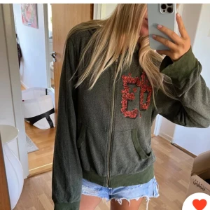 Kofta - Supercool ziptröja som är köpt här på Plick, lånade hennes bilder. Den är grön med röda detaljer