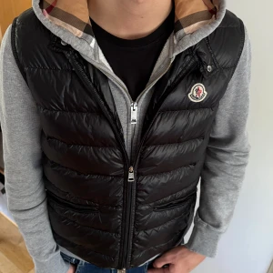Moncler gui väst - Säljer nu min moncler gui väst pga använder den inte. Västen har bara hängt i garderoben och är i ny skick. 10/10 skick. kvitto och Annat äktehetsbevis finns så klart hör av er om ni har några frågor. Mvh 