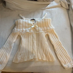 Stickad offshoulder tröja med rosetter och spets - Världens sötaste tröja, fick i present men aldrig använt då det inte är min stil. Storlek M, köparen står för frakten 💗
