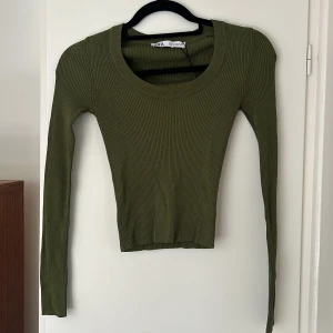 Långärmad tröja från zara - Superfin militärgrön tröja från zara med perfekt U-ringning, väldigt tajt men stretchig. Använd en gång så kvaliteten är bra!😊