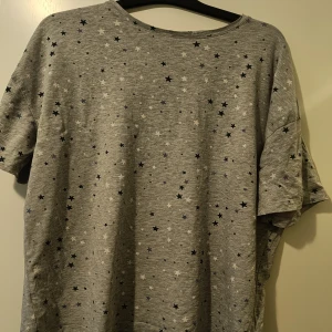T-shirt/Sovtröja med stjärnor - T-shirt/Sovtröja med stjärna.  Märke Cubus  Storlek: L  Använd men övervägande stjärnor är intakta. Använd men ändå i bra skick. Mer ljusgrå i verkligheten än på bilderna. 