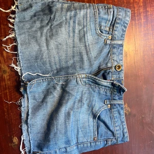 Jeanskjol med fransig kant - Säljer en cool jeanskjol med fransig kant. Perfekt för sommardagar eller festivaler! Den har en klassisk blå jeansfärg och fem fickor. Dragkedja och knapp framtill. Superbekväm och lätt att matcha med allt! 💙