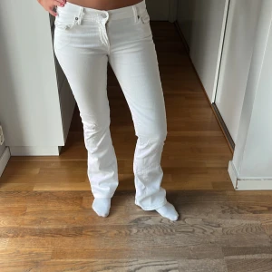Lågmidhade jeans  - Lågmidjade, utsvängda, vita jeans i jätte bra skick knappast använda!
