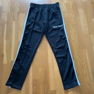 Palm angels byxor svarta stl S - Palm angels byxor svarta stl S i bra skick, dock en släpp på en söm på ena byxbenet (se bild) säljes pga att de blivit försmå 700 kr, köparen står för frakten 