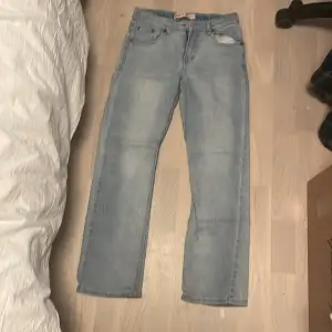 Säljer ett par snygga ljusblå Levi's 512 jeans i straight fit. De är i bra skick och har den klassiska femficksdesignen med en dragkedja fram. Perfekta för en avslappnad stil och passar till det mesta i garderoben.